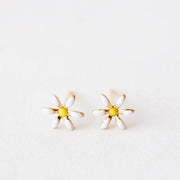 Small daisy stud earrings with a yellow center and white petals. The material is gold plated and the post is a straight back.