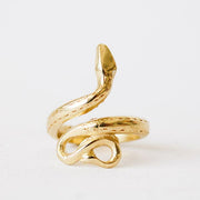 In front of a white background is a gold snake ring. The tail is at the bottom and the body and head curves around to the top of the ring.