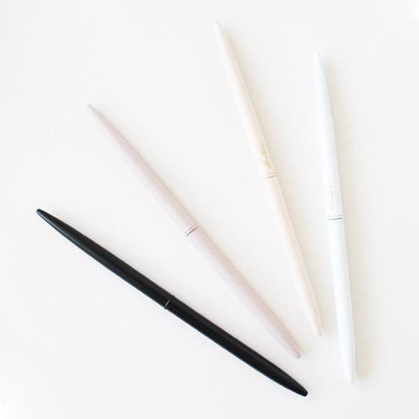On a white background is a set of four matte pens with neutral colors and a black pen.