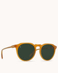 In front of a white background is a pair of round, orange sunglasses with green lenses.