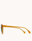 In front of a white background is the side view of a pair of round, orange sunglasses.