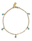 In front of a white background is a thin gold chain bracelet. The bracelet has five circle turquoise stone charms.
