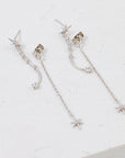 A dainty dangly earring with a star stud and a chain hanging down the back side and a wavy cubic zirconia studded down the front.