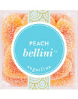 Birds eye view of the top of a clear plastic cube container. The container is filled with peach colored heart shaped gummies coated in white sugar. On the top of the container is a bright blue circle sticker with white text that reads ‘peach Bellini.’