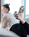 Fuzzy leopard slippers with a crisscross detail.