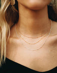 Woman modeling Aria Necklace, find gold chain with small beads.