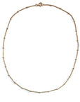 Fine gold chain necklace with gold beads.