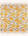 A 70's style yellow and orange floral picnic mat with cream fringe detailing around the edges.