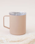 A light pink travel mug with a handle and a snap on lid.