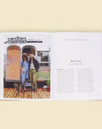 Two open pages of the book. The left page is filled with a sweet couple looking down at their long haired cat, posed in front of their silver airstream trailer. The right page is titles 'For Love' and dives into the story of Jenny and Chelsea Wilder against a solid white page.