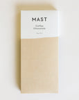 A rectangle chocolate bar packaged in a white and tan wrapper with black text that reads, "MAST Coffee Chocolate".