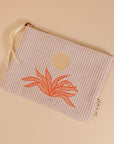 A light pink corduroy pouch with a sun and an orange aloe plant graphic in the center. The pouch has a single zipper going across the top.