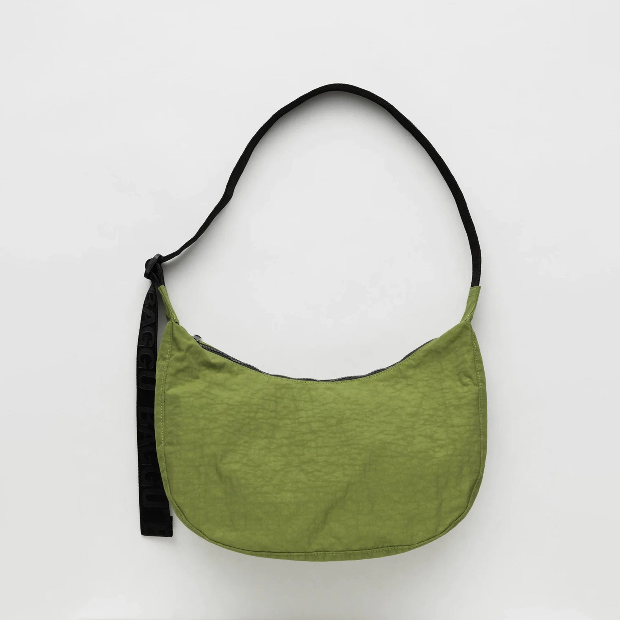 A vibrant green nylon crescent shaped bag with an adjustable black strap and a single zipper.