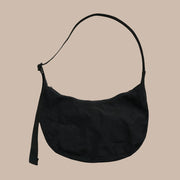 A nylon crescent shoulder bag with an adjustable strap and a single zipper. The interior also features a zipper for optimal organization.