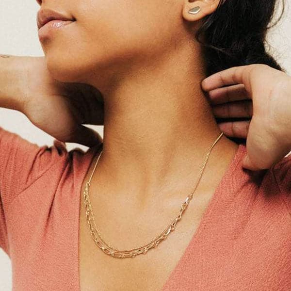 Woman modeling the Aya Necklace, a gold two chain necklace with a thin chain and big chain.