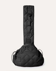 A black quilted puffer material crossbody pet carrier bag photographed with a small black and white dog in it and a zipper that fits an iPhone.
