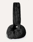 A black quilted puffer material crossbody pet carrier bag with a thick strap, a side zipper and a drawstring adjuster.