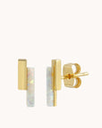 On a white background is a pair of stud earring with two vertical bars staggered against one another. One is opal and the other is gold plated.