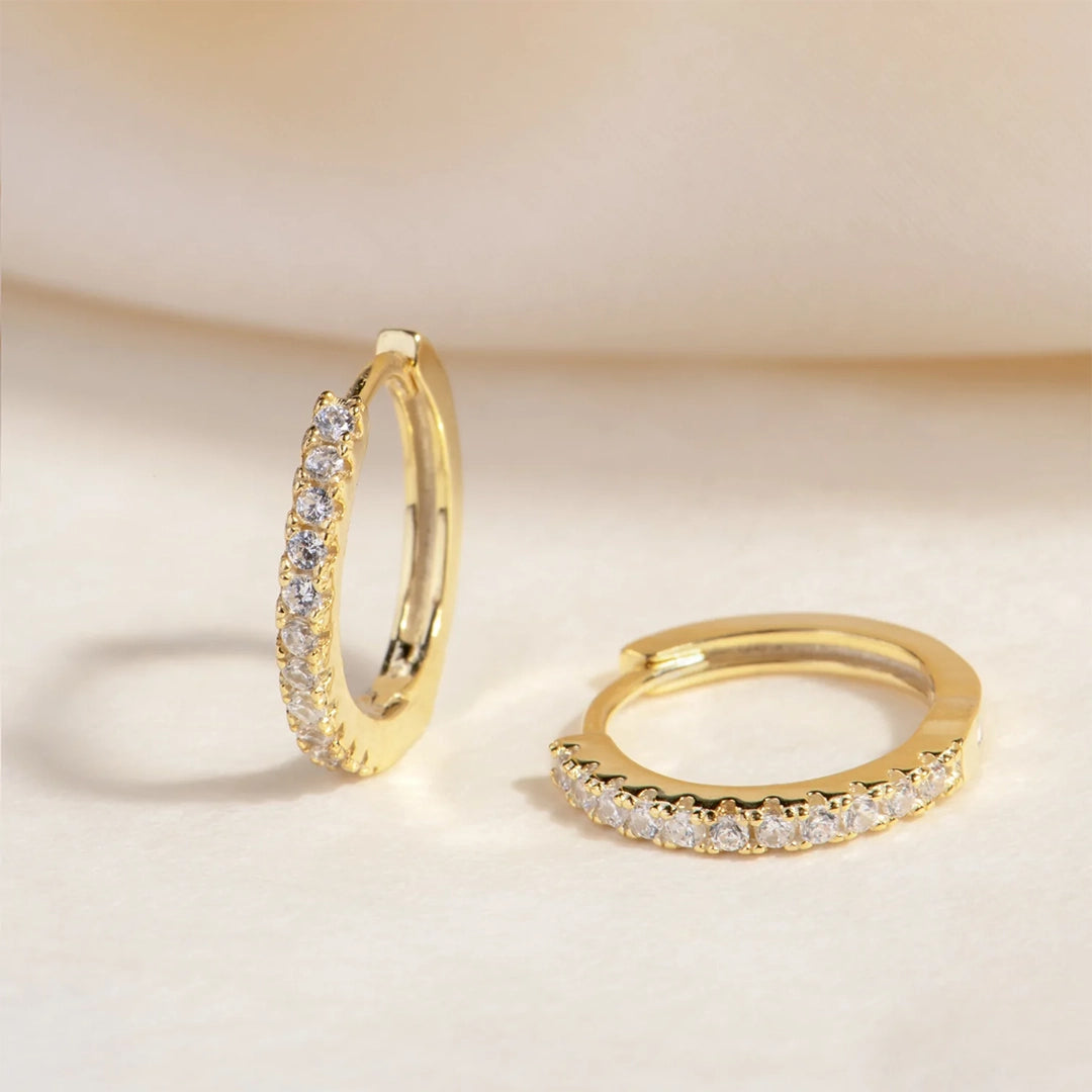 Gold huggie hoops with small CZ stones.