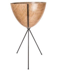In front of a white background is a wood colored bullet planter. The planter has a wide top and narrows at the bottom. The planter is held up by a black metal stand. The stand has three black metal legs.