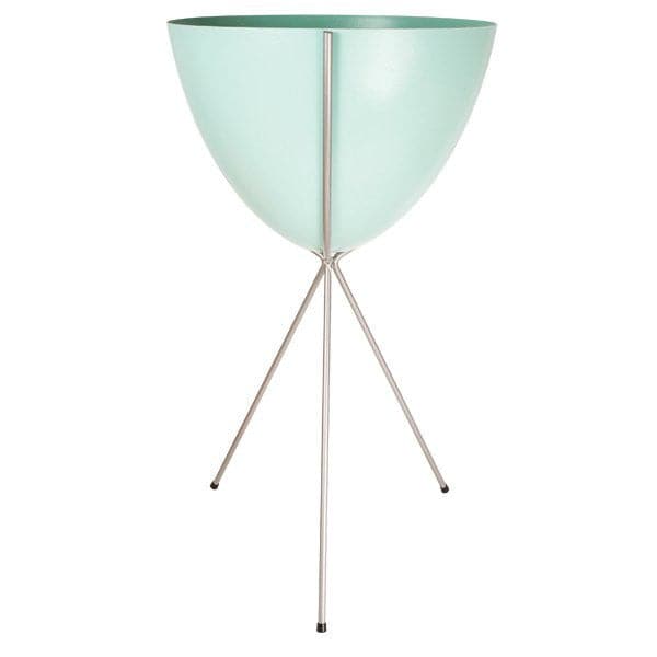 In front of a white background is a turquoise colored bullet planter. The planter has a wide top and narrows at the bottom. The planter is held up by a silver metal stand. The stand has three silver metal legs.