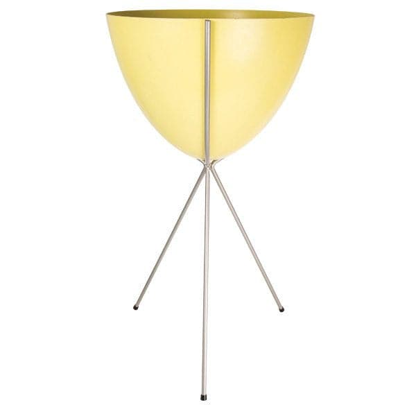 In front of a white background is a yellow colored bullet planter. The planter has a wide top and narrows at the bottom. The planter is held up by a silver metal stand. The stand has three silver metal legs.