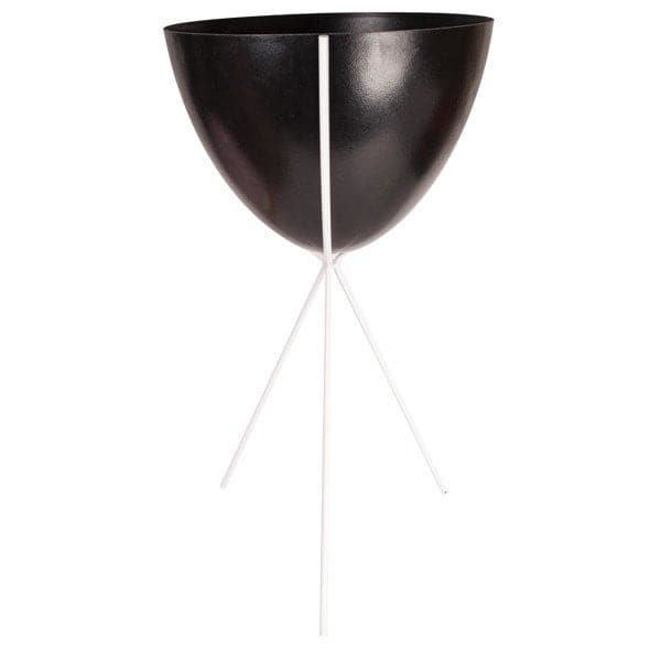 In front of a white background is a black colored bullet planter. The planter has a wide top and narrows at the bottom. The planter is held up by a white metal stand. The stand has three white metal legs.