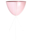 In front of a white background is a pink colored bullet planter. The planter has a wide top and narrows at the bottom. The planter is held up by a white metal stand. The stand has three white metal legs.
