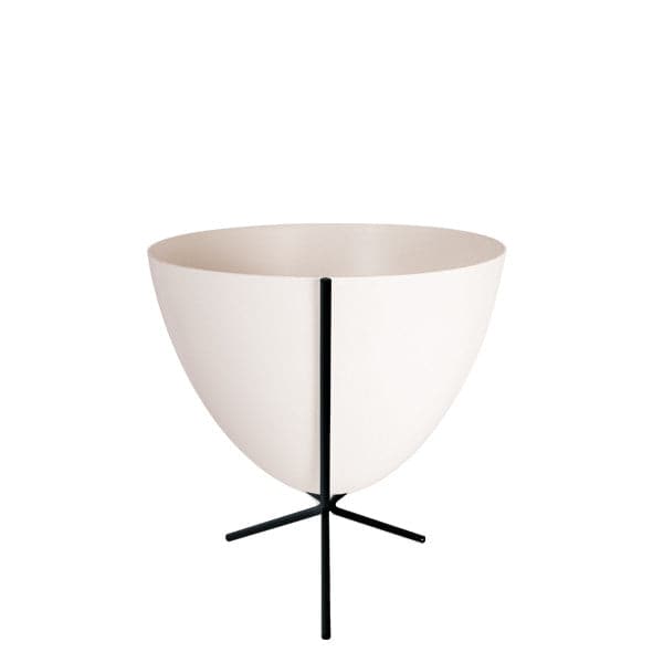 In front of white background is a white planter in a short black metal stand. The bullet planter is wide at the top and narrow at the bottom. The metal stand has three legs. 