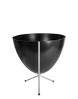In front of white background is a black planter in a short silver metal stand. The bullet planter is wide at the top and narrow at the bottom. The metal stand has three legs.