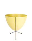 In front of white background is a yellow planter in a short silver metal stand. The bullet planter is wide at the top and narrow at the bottom. The metal stand has three legs.