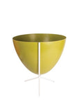 In front of white background is an olive green planter in a short white metal stand. The bullet planter is wide at the top and narrow at the bottom. The metal stand has three legs.