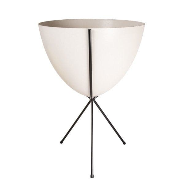 In front of white background is a white planter in a black metal stand. The bullet planter is wide at the top and narrow at the bottom. The metal stand has three legs. 