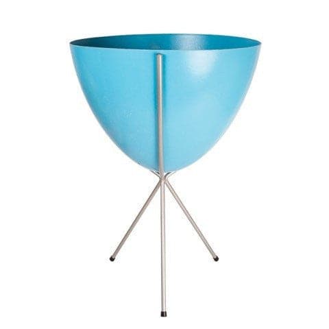 In front of white background is a bright blue planter in a silver metal stand. The bullet planter is wide at the top and narrow at the bottom. The metal stand has three legs. 