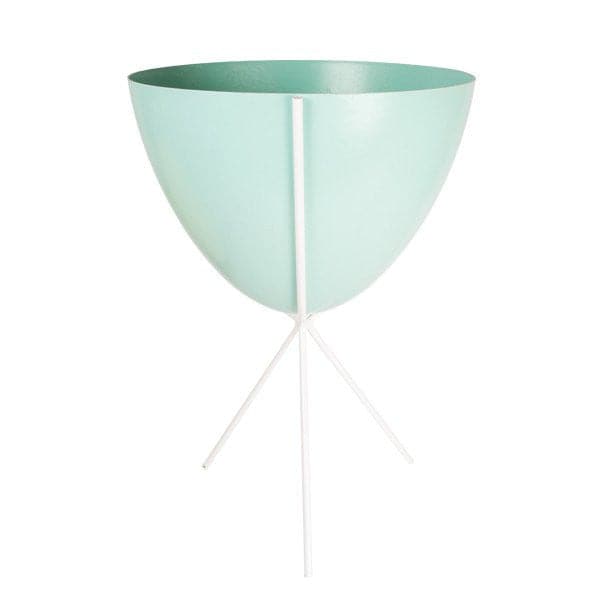 In front of white background is a turquoise planter in a white metal stand. The bullet planter is wide at the top and narrow at the bottom. The metal stand has three legs. 