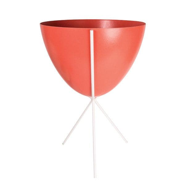 In front of white background is a red planter in a white metal stand. The bullet planter is wide at the top and narrow at the bottom. The metal stand has three legs. 