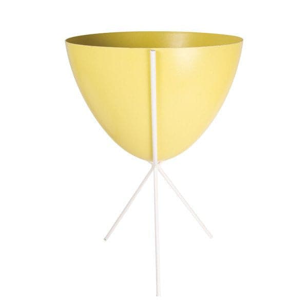 In front of white background is a yellow planter in a white metal stand. The bullet planter is wide at the top and narrow at the bottom. The metal stand has three legs. 