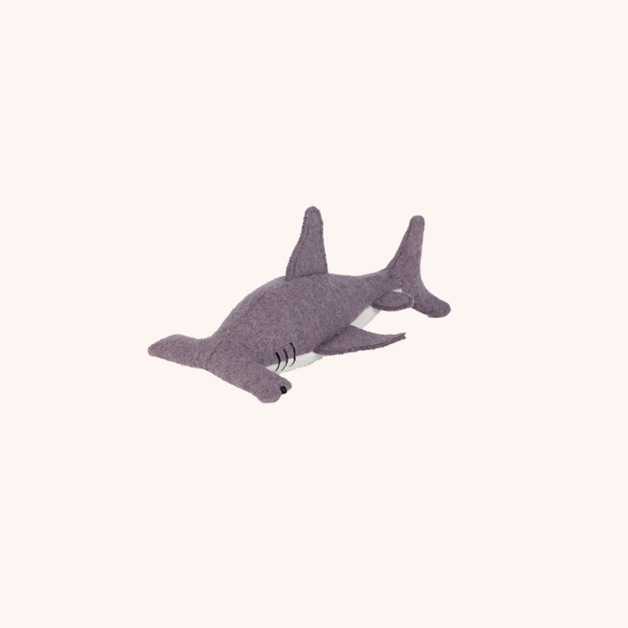 A dark gray and white hammerhead shark stuffed toy.