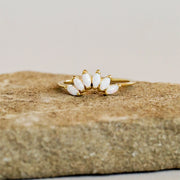 A thin gold band with six opal stones places like a crown on the front of the ring.