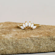 A thin gold band with six opal stones places like a crown on the front of the ring.