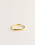 Delicate gold ring with etched suns and moons circling the band. Each sun and moon has a CZ gem in the center.