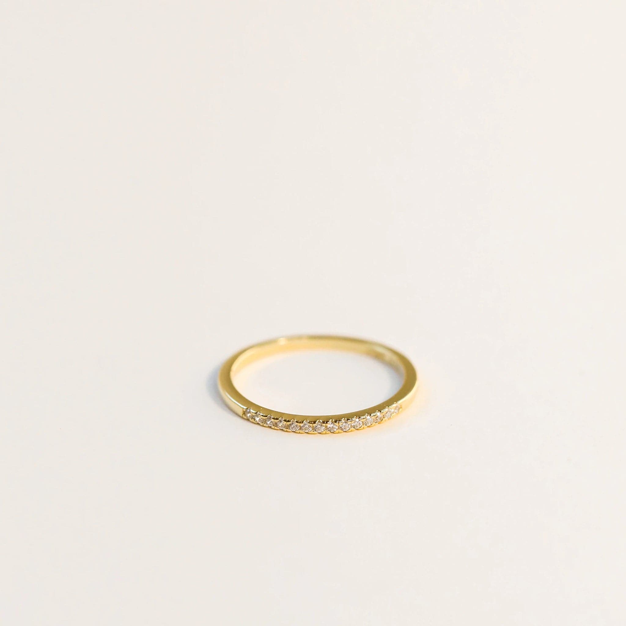 A delicate gold ring with a half pave design. This ring's band is thin, which is perfect for stacking.