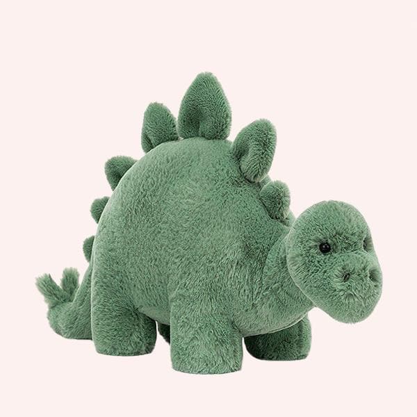 On a white background is a green stegosaurus stuffed animal. 