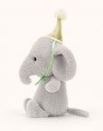 Soft stuffed animal in the shape of a dove grey animal wearing a pompommed party hat tied with satiny ribbon