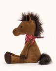 Soft stuffed animal in the shape of a brown horse with fluffy dark brown mane and tail, and wearing a red and white spotted bandana around its neck.