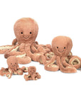 Four different sized pink octopus stuffed animal with a smiling face photographed on a cream background.