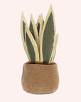 back view of A soft suede stuffed animal in the shape of a potted snake plant, with spikey dark and light green leaves, and brown textured pot with smiley face and dark brown floppy legs.