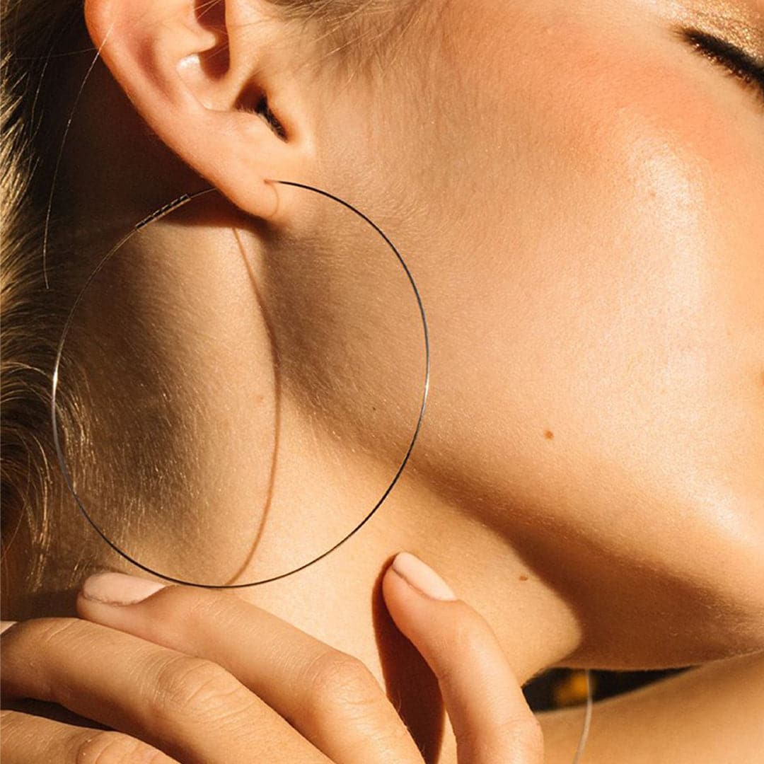 A model wearing these hoop earrings that are super thin and gold. 