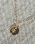 Long gold chain and circle gold pendant with crystal gemmed star charm.