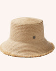 A woven bucket hat in a light straw color with a frayed edge detail along the edge of the brim and a tiny hemlock hat metal emblem in the center.